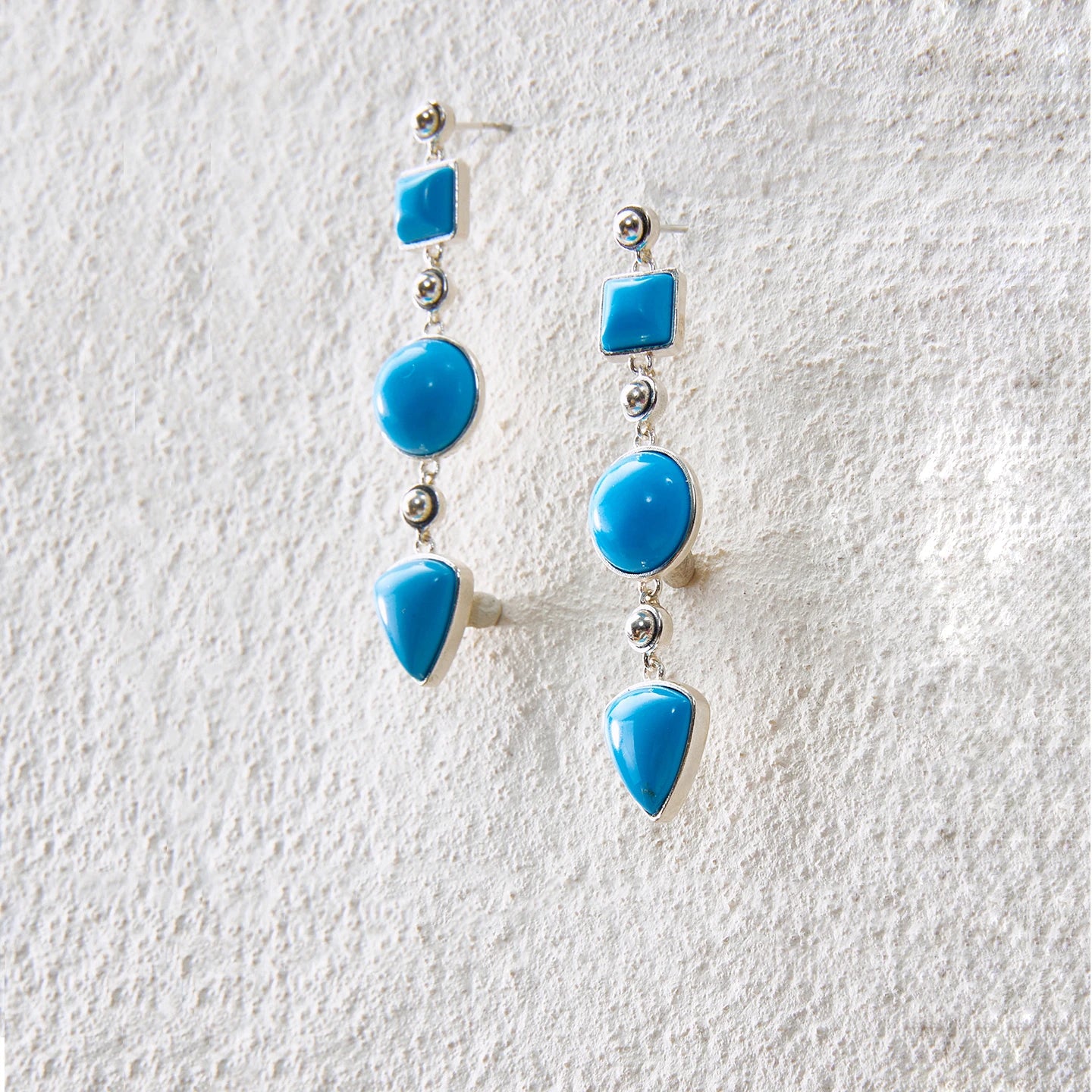 Long drop earrings with turquoise geometric motifs, blending tribal essence and modern aesthetics