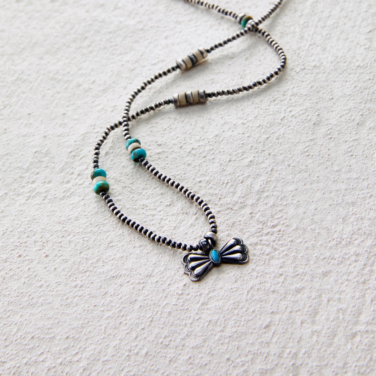 Vintage-style butterfly pendant necklace with turquoise accent and beaded chain