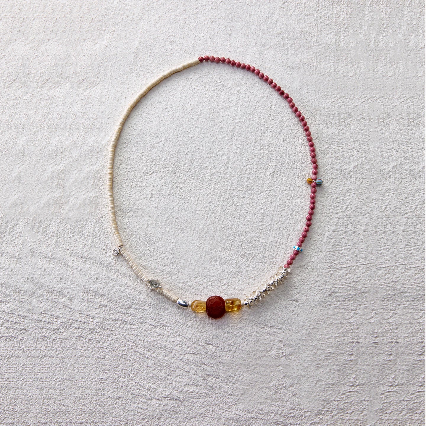 A handcrafted beaded necklace with rhodochrosite and citrine, radiating warmth and vitality