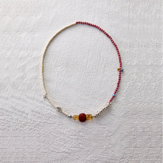 A handcrafted beaded necklace with rhodochrosite and citrine, radiating warmth and vitality