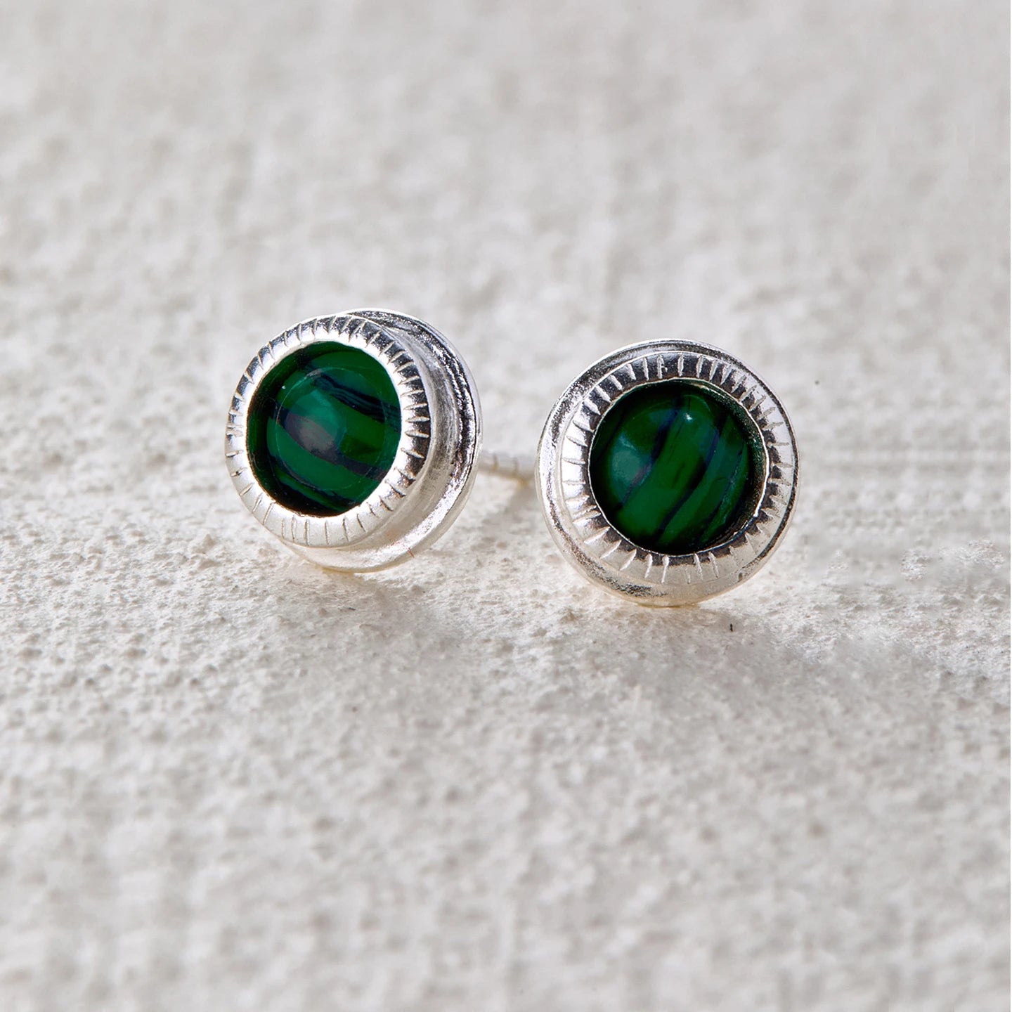 Round malachite stone set in the center of silver studs, radiating a natural and mystical vibe