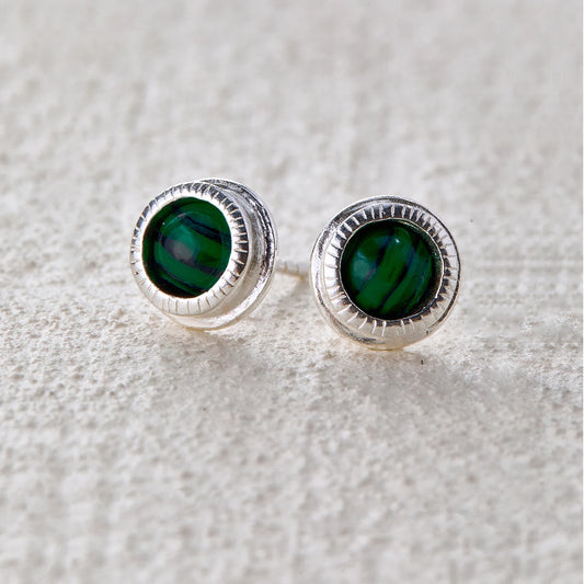 Round malachite stone set in the center of silver studs, radiating a natural and mystical vibe