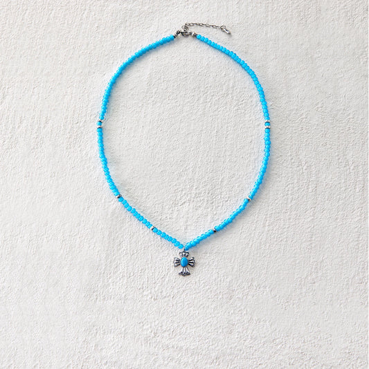 Blue glass beaded necklace with cross-shaped pendant, blending grace and mystique
