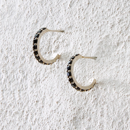 Small silver arc hoop earrings inlaid with black onyx for a sleek and mysterious tone