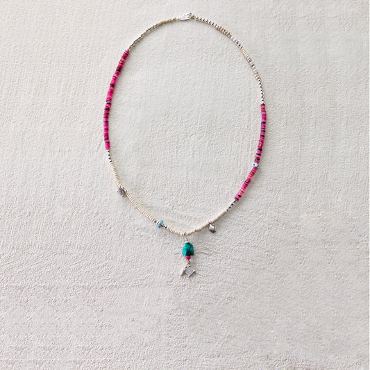 A tribal-style necklace featuring dyed shell and turquoise, symbolizing freedom and wishes