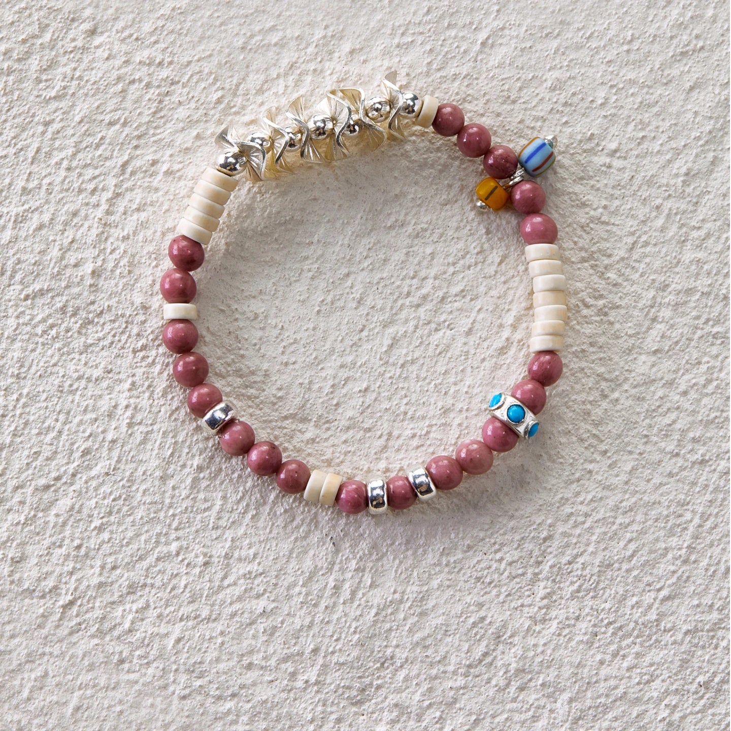 Bracelet featuring rhodochrosite, white turquoise, and glass beads