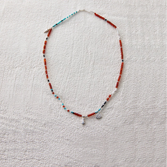 Beaded necklace made of red agate, turquoise, and white jade, adorned with star and coin-like charms