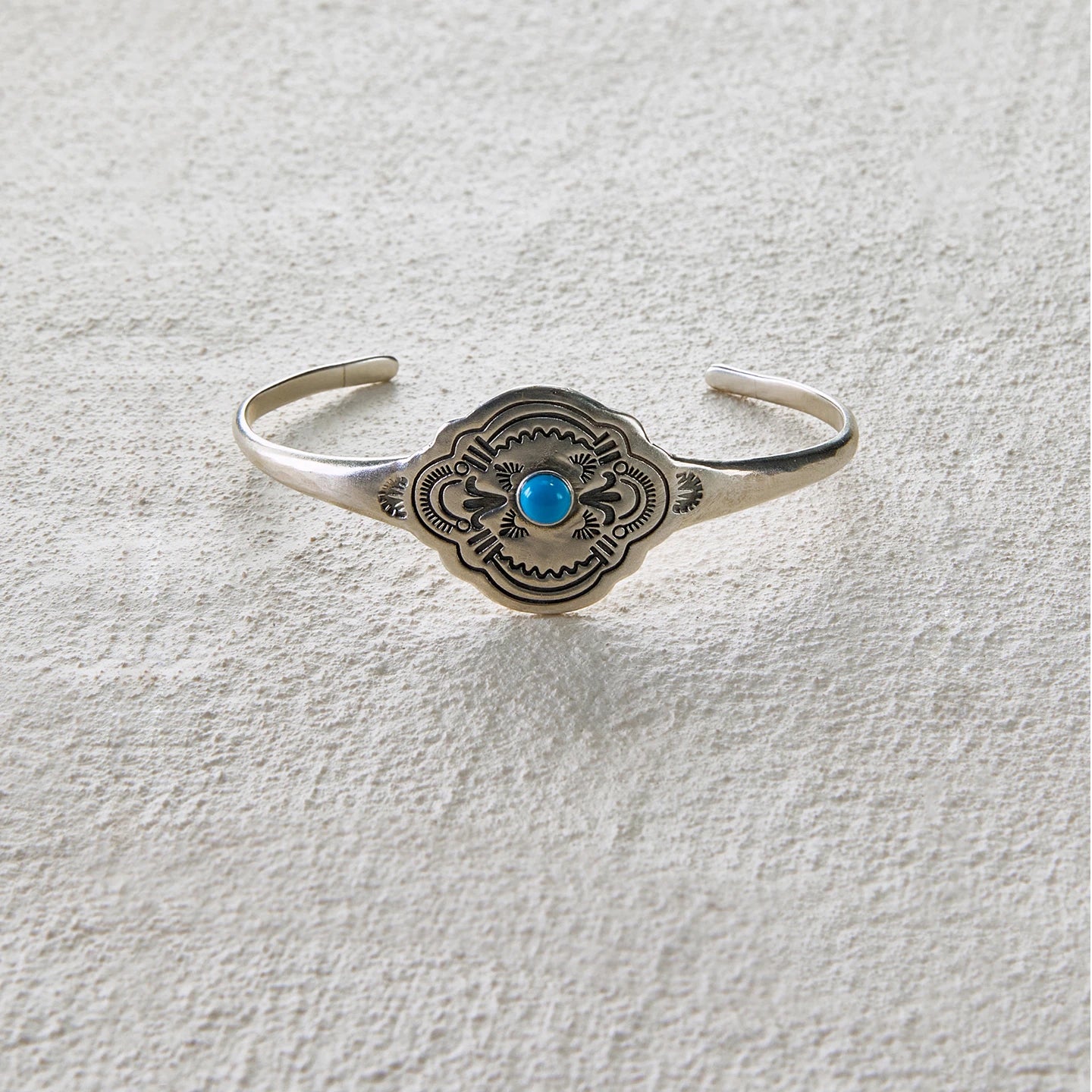 Totem-style open cuff with central turquoise inlay