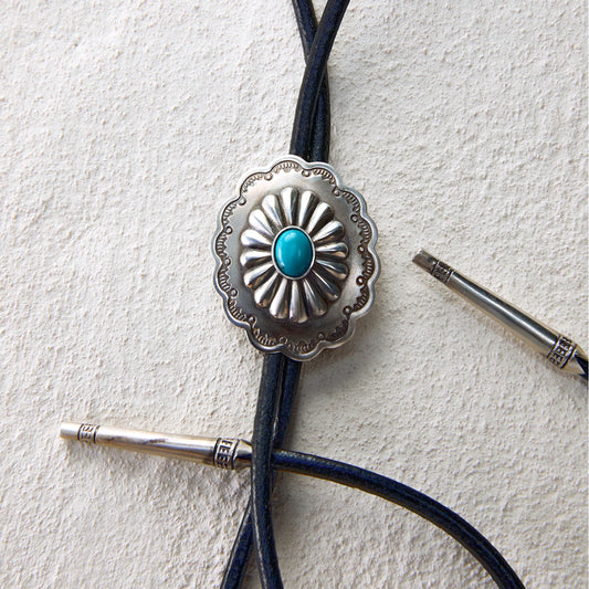 Western bolo tie with turquoise-inlaid floral concho and leather cord