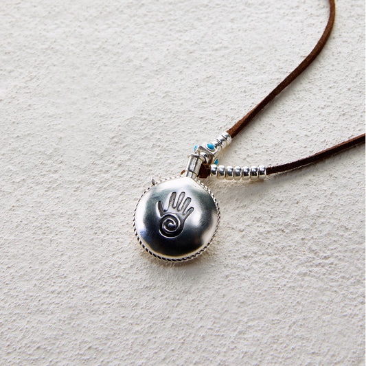 Pendant necklace featuring a silver totem hand flask with turquoise accents