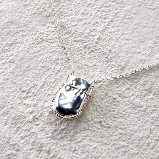 Silver pendant necklace in the shape of a treasure pouch, inspired by Eastern blessings