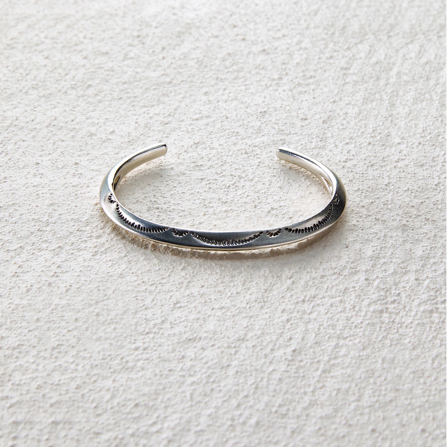 Sterling silver open cuff engraved with wave patterns