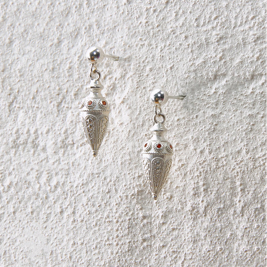 Silver cone-shaped earrings with ornate carvings, symbolizing wishes and sacred rituals