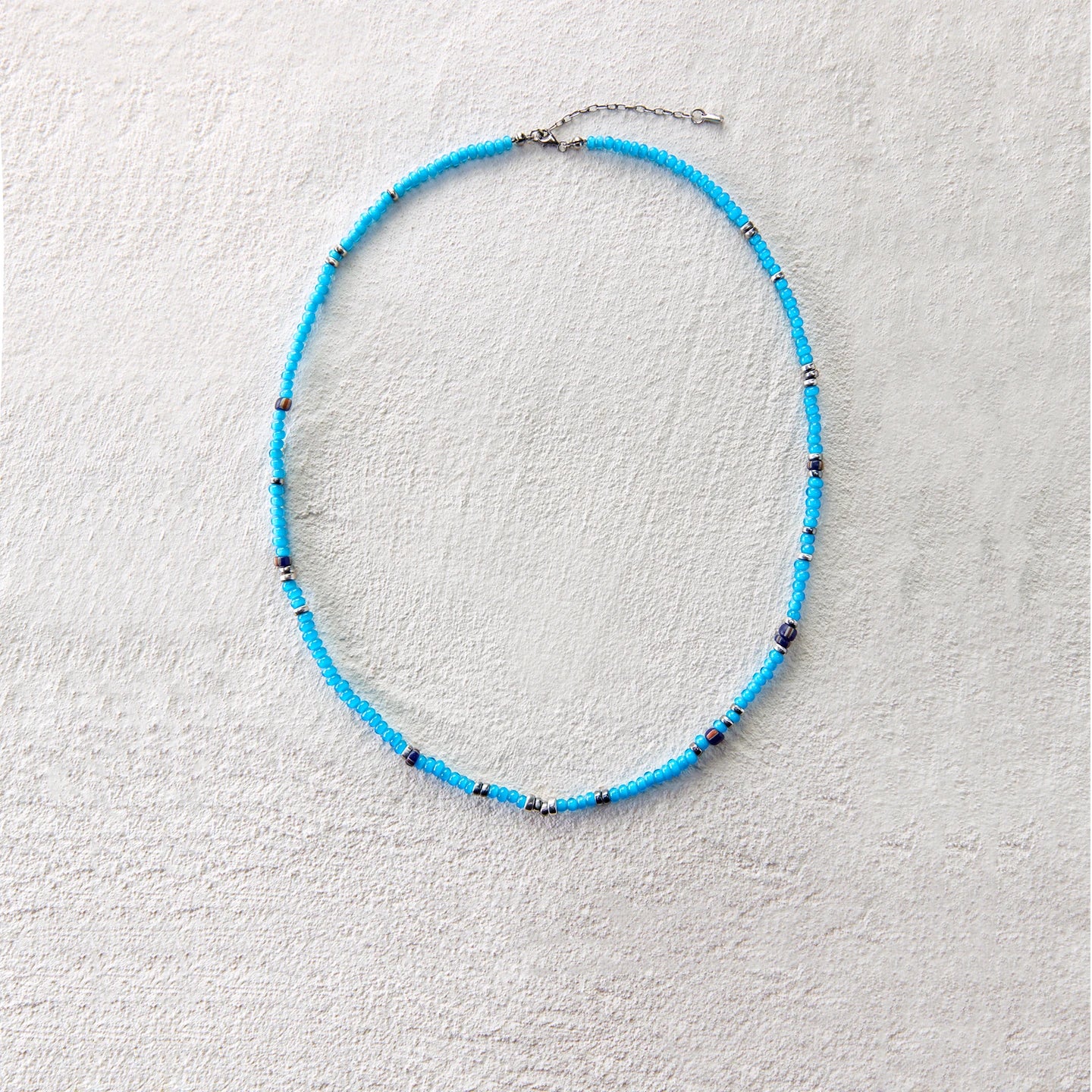 Blue glass beads with silver accents, creating a vibrant and breezy summer look