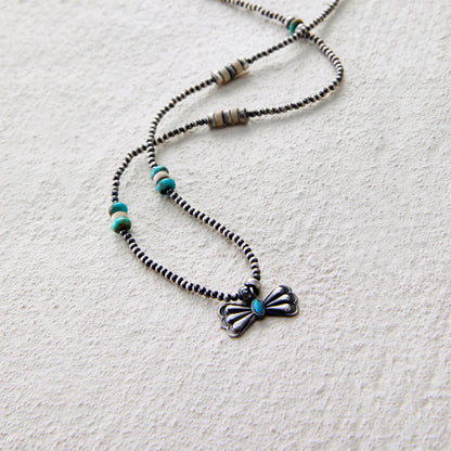 Vintage-style butterfly pendant necklace with turquoise accent and beaded chain