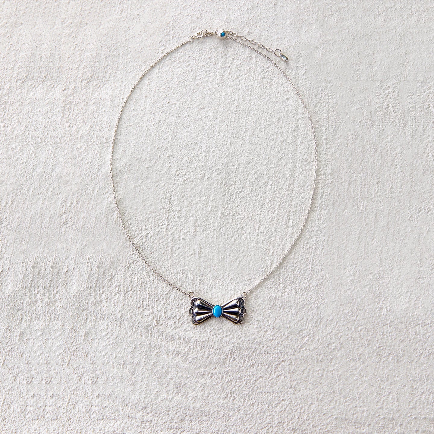 Vintage-style silver bead necklace with butterfly charm and turquoise