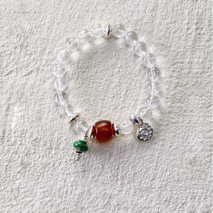 Bracelet featuring clear quartz beads with carnelian and turquoise charms