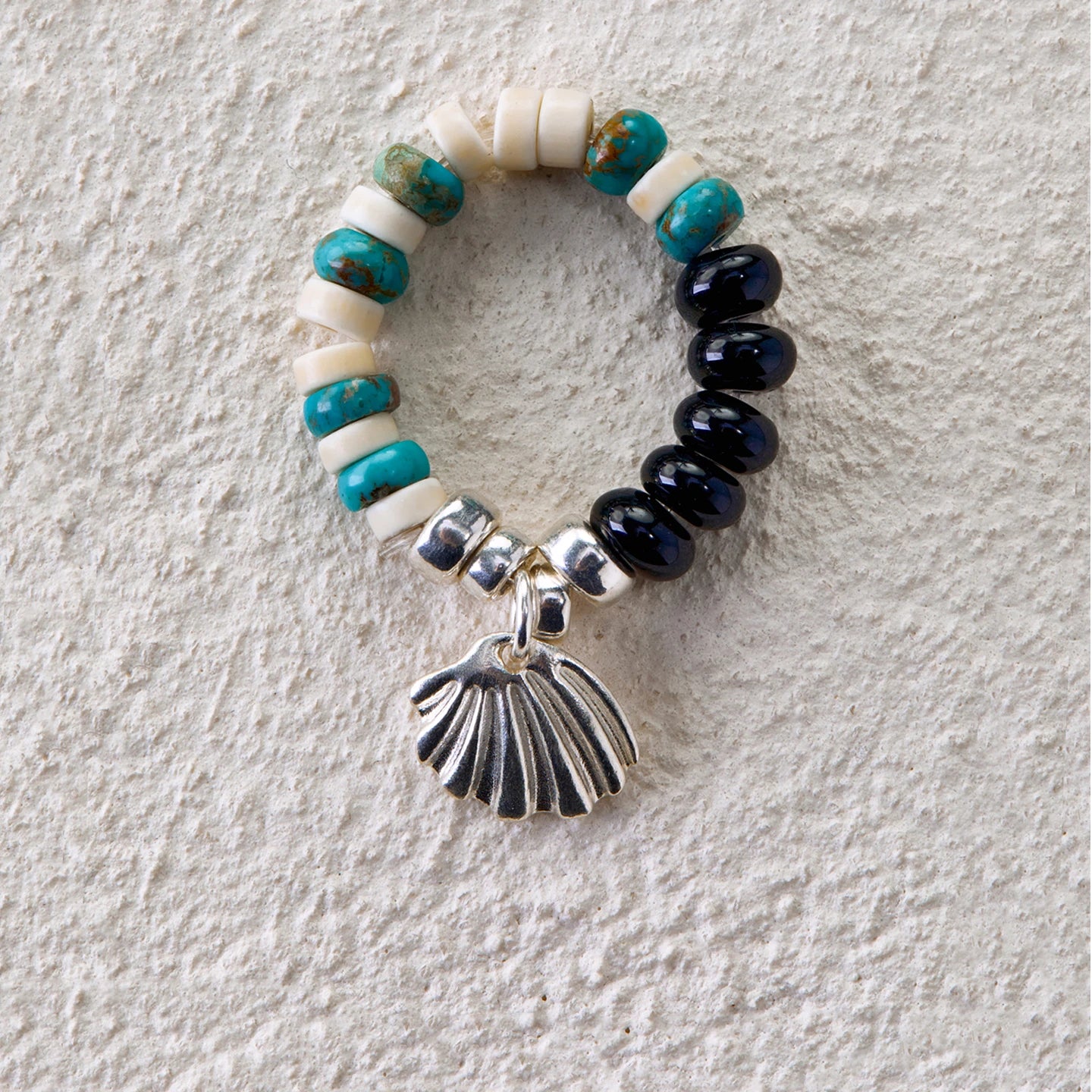 Beaded ring with turquoise, white turquoise, black onyx, and silver seashell charm