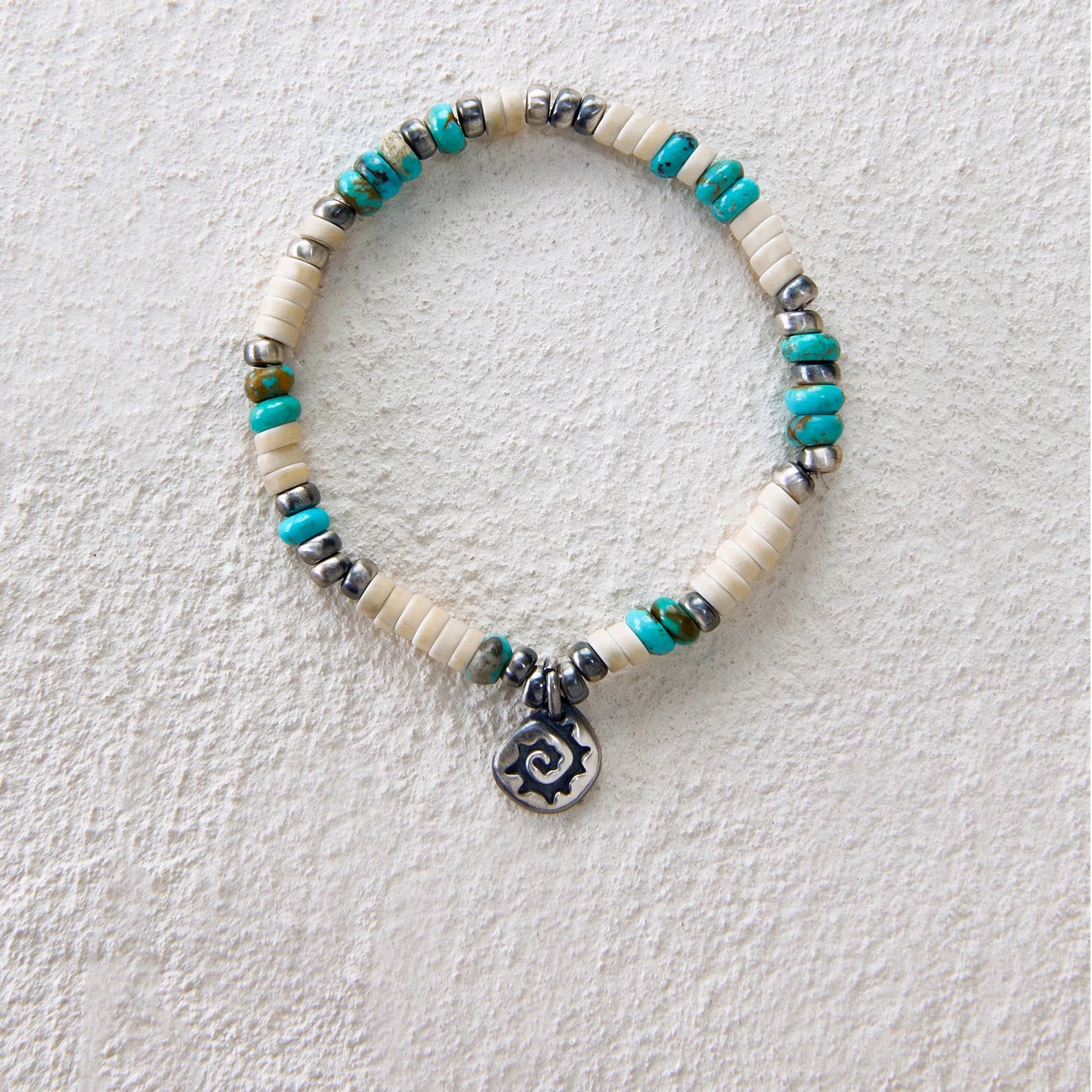 Bracelet featuring turquoise, white howlite and a spiral charm